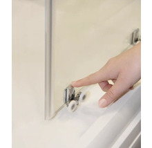 Detail sprchového koutu s válečkovým vedením a prstem dotýkajícím se válečku.