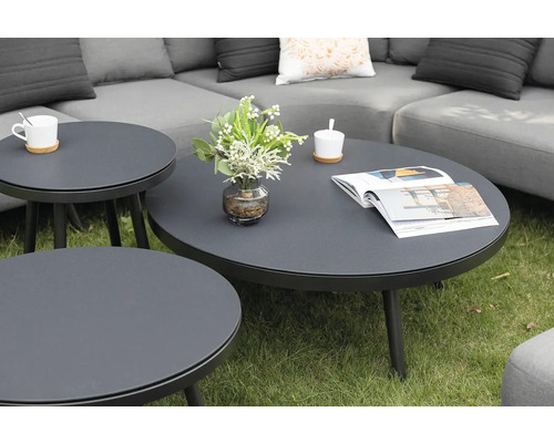 Skupina kulatých zahradních stolků na trávníku