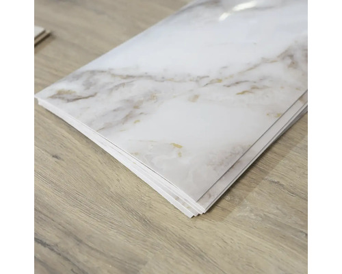 Několik bílých vinylových podlahových dlaždic se vzhledem mramoru na dřevěné podlaze