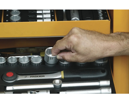 Ruka sahá po nástrčném klíči velikosti 27 v kufříku s nářadím