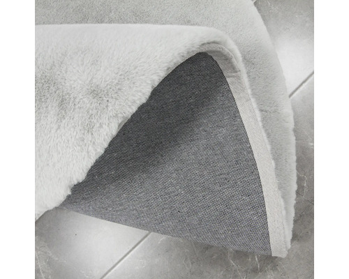 Detailní pohled na světlý koberec s vlasem a textilní zadní stranou