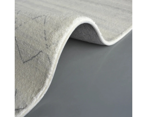 Detail světlého koberce s geometrickým vzorem