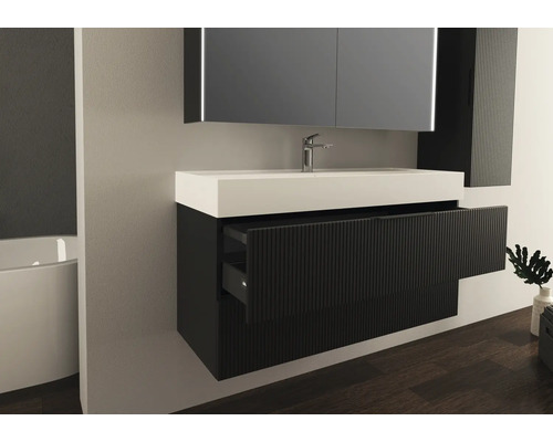 Moderní koupelna s umyvadlem, zrcadlem a úložnými zásuvkami.