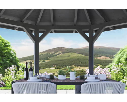Dřevěný zahradní pavilon s prostřeným stolem a výhledem na kopcovitou krajinu