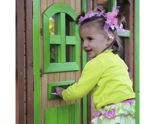 Mladá dívka vkládá dopis do poštovní schránky hracího domku