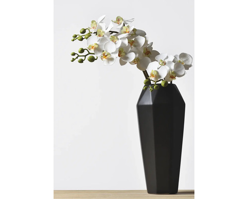 Umělá orchidej ve váze jako dekorace.