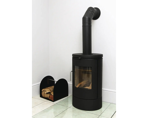 Černá kamna na dřevo s dřevem a košem na dřevo ve světlé místnosti.