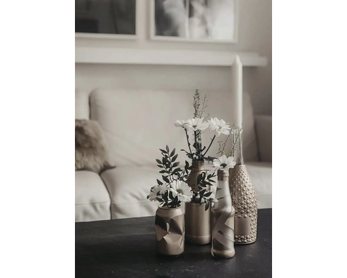 Dekorativní stolní scéna s květinami ve vázách před pohovkou