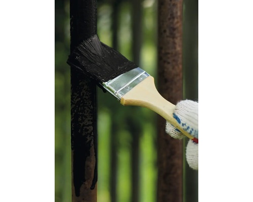 Natírání kovového plotu štětcem