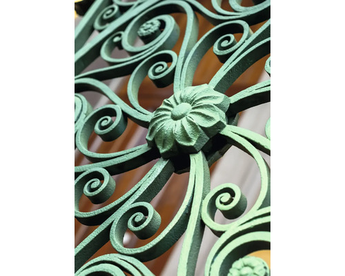 Detail zdobeného kovového zábradlí s květinovým motivem