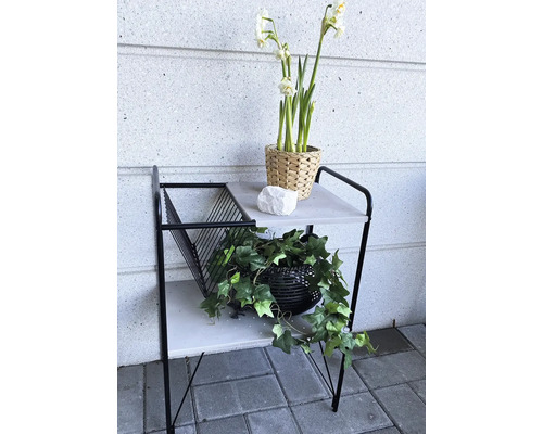 Dekorativní odkládací stolek se dvěma policemi, květinovou výzdobou a sbírkou časopisů do interiéru.