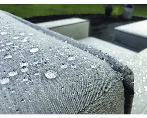 Detailní záběr vodoodpudivého polštáře zahradního nábytku s kapkami vody.