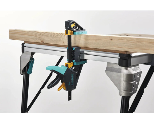 Pracovní stůl s kusem dřeva upevněným šroubovací svorkou Wolfcraft