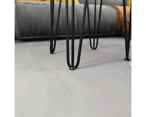 Detailní pohled na černé kovové nohy stolu v designu vlásenky