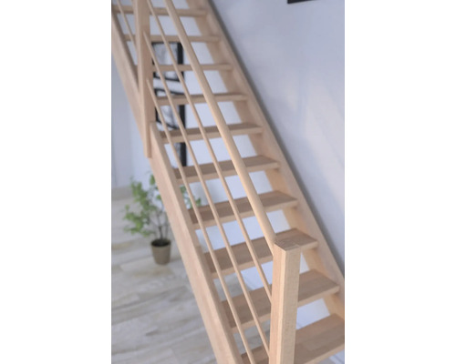 Dřevěné schodiště se zábradlím ve světlé místnosti.