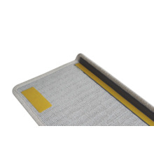 Detailní pohled na šedý schodišťový nášlap s lepicí páskou pro upevnění.