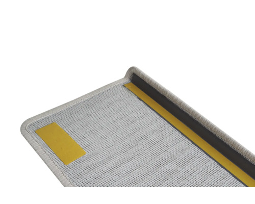 Detailní pohled na šedý schodišťový nášlap s lepicí páskou pro upevnění.