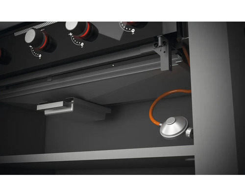 Vnitřní pohled na plynový gril s ovládacími prvky a připojením plynu