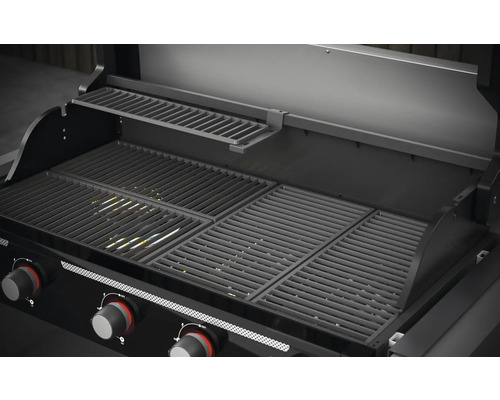 Vnitřní pohled na plynový gril s grilovacím roštem a ohřívacím roštem