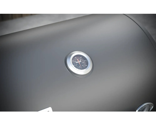 Detailní záběr víka grilu s ukazatelem teploty.