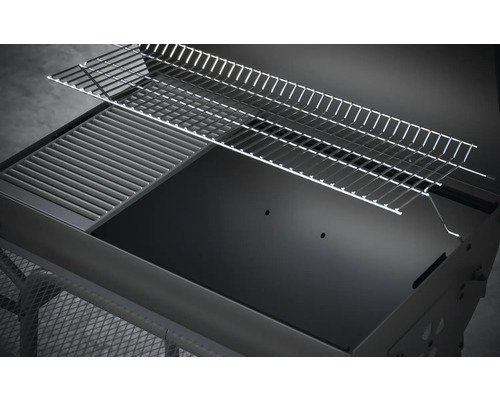 Detailní pohled na gril na dřevěné uhlí s roštem a ohřívacím roštem.