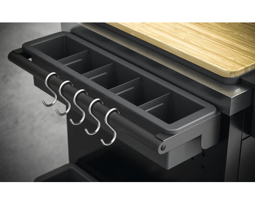 Detailní pohled na grilovací stanici s nádobou na grilovací příslušenství a kovovými háčky