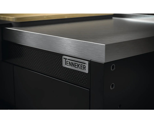 Detailní pohled na černou dílenskou skříňku s nerezovou pracovní deskou a logem Tenneker
