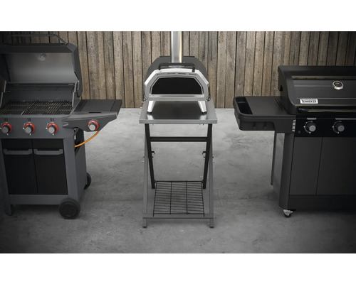 Tři různé grily ve venkovním prostředí: plynový gril, pec na pizzu a další gril.