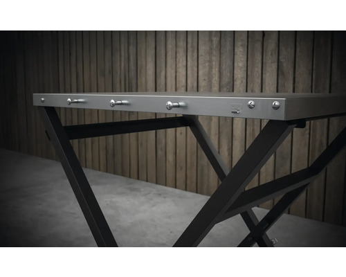 Detailní pohled na skládací stůl s kovovým rámem a háčky