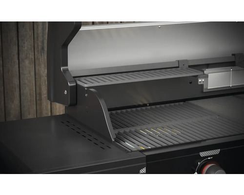 Detail otevřeného plynového grilu s grilovacím roštem