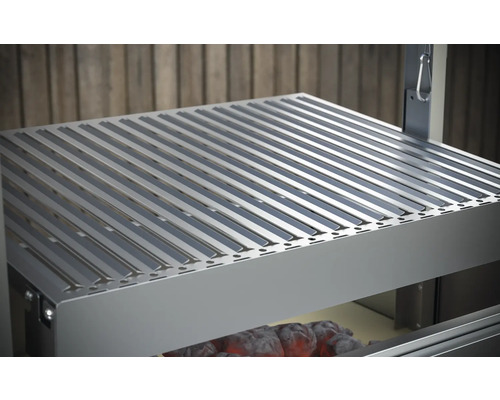 Kovový grilovací rošt nad dřevěným uhlím