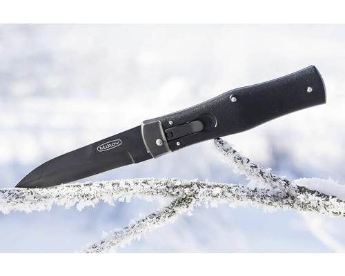 Černý vystřelovací nůž Mikov na větvi pokryté námrazou