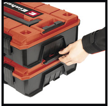 Ruka otevírá dva kufříky na nářadí značky Einhell.