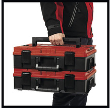 Dva červené a černé kufříky na nářadí, které nese jedna osoba.