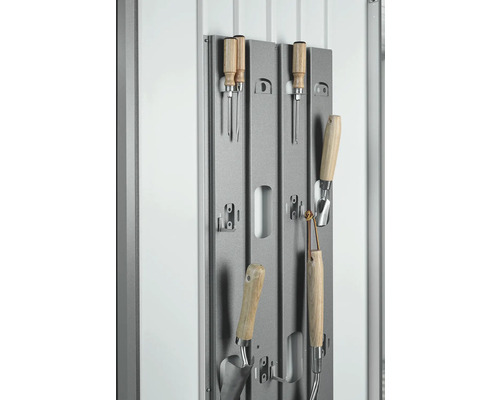 Zahradní nářadí na šedém kovovém držáku pro skladování.