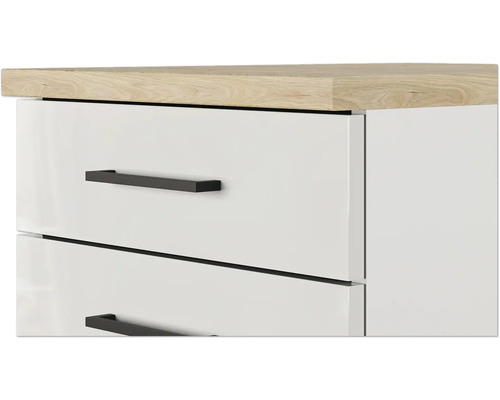Detailní záběr bílého nábytku se zásuvkami a světle hnědou dřevěnou deskou