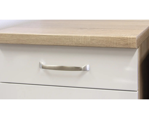 Detail bílé skříně se zásuvkami a madlem