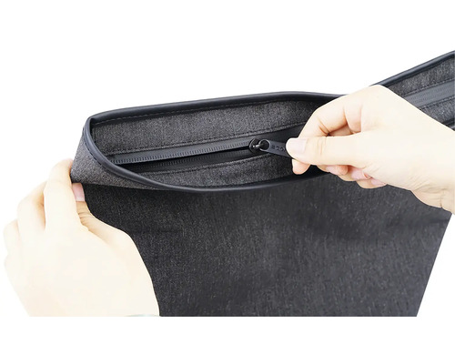 Detail šedé tašky se zipem ovládaným rukama