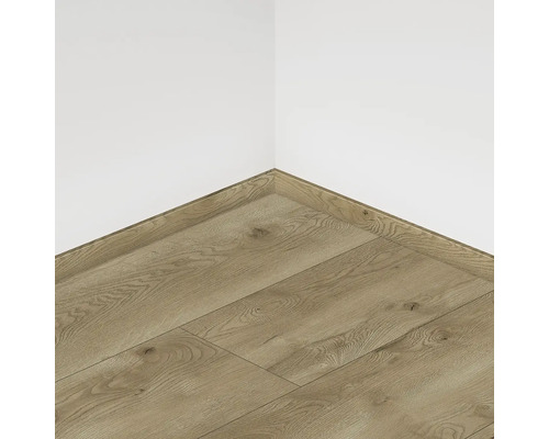 Položená laminátová podlaha se soklovou lištou u bílé stěny