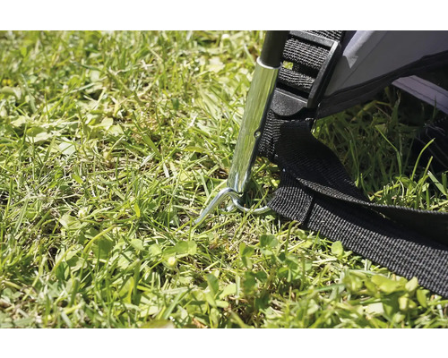 Detail kolíku stanu v trávě.