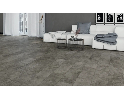 Obývací pokoj s šedou dlažbou s kamenným vzhledem, gaučem, stolem a oknem pro světlé, moderní prostředí.