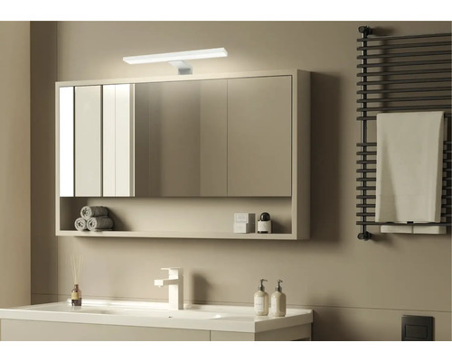 Moderní koupelna se zrcadlovou skříňkou, umyvadlem, radiátorem na ručníky a minimalistickým designem