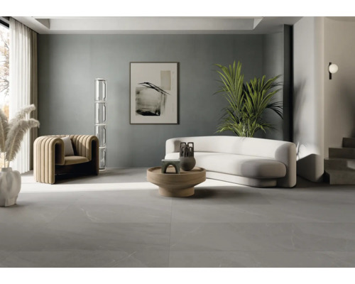 Světlý obývací pokoj s křeslem, pohovkou, stolem a dlažbou.