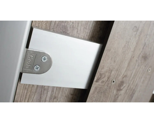 Detailní pohled na kování nábytku se šrouby a logem výrobce