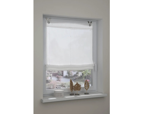 Okno s bílou skládanou roletou a dekorací na okenním parapetu