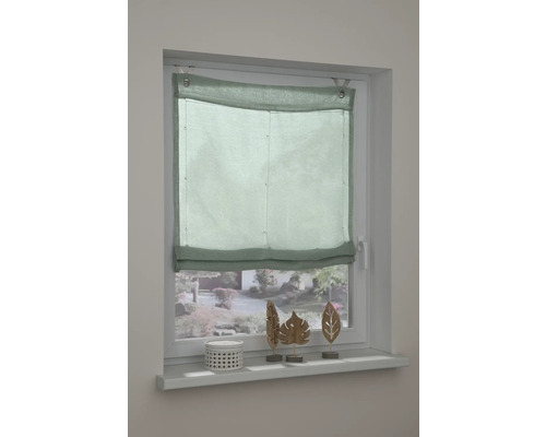 Pohled na okno se zelenou římskou roletou.