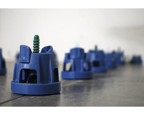 Několik vyrovnávacích systémů dlaždic na podlaze.