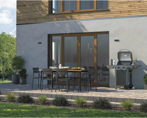 Terasa s grilem, jídelním stolem a židlemi před domem