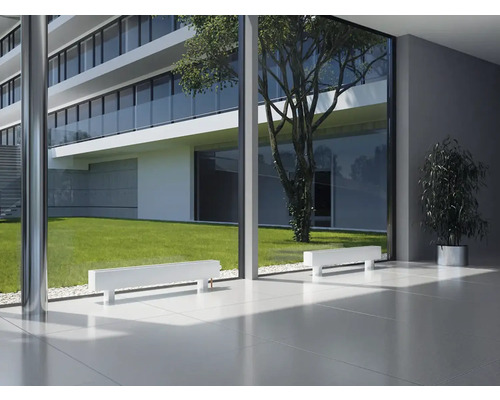 Interiér s bílými radiátory před velkým oknem s výhledem do zahrady