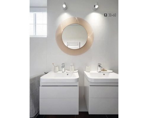 Koupelna se dvěma skříňkami pod umyvadlo, kulatým zrcadlem a osvětlením